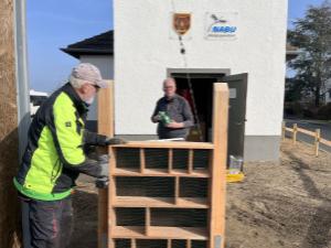 Das große Insektenhaus wird vor dem Turm aufgestellt.